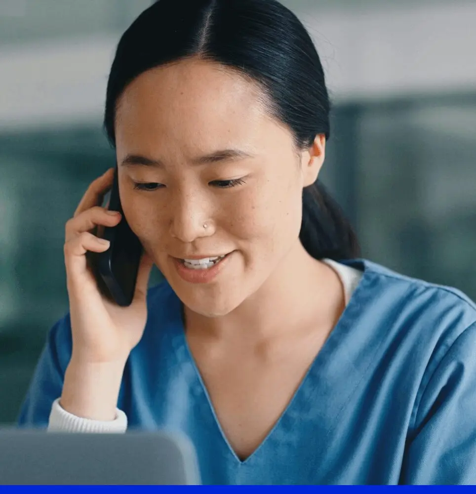 Doctor speaking on phone while looking at computer