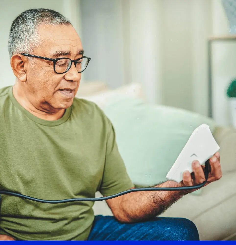 Elderly man using blood pressure device